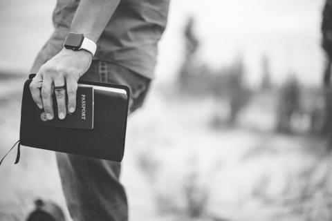 Man holding passport and Bible by Ben White | Lightstock | Used by Permission