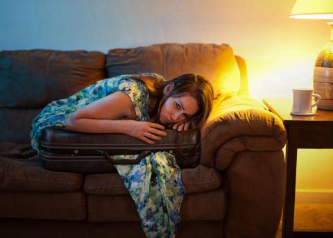 A sad woman sitting in a suitcase by KevinCarden | Lightstock | Used by Permission