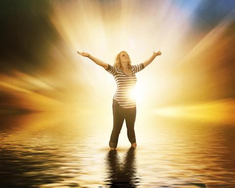 Woman with arms raised and glowing light behind her by Kevin Carden | Lightstock | Used by Permission