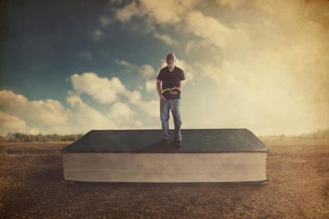 Man standing on giant Bible by Kevin Carden | Lightstock | Used by Permission