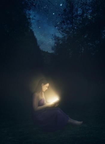 Woman reading shining Bible in the dark by Kevin Carden | Lightstock | Used by Permission